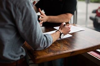 Teamwork Two people discussing business over a wooden table